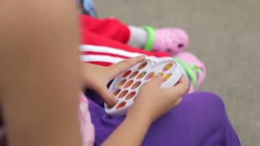 Çocuk kız elleri popüler silikon anti-stres oyuncağıyla oynuyor. Patlat onu ve basit bir gamze. Yakın plan.