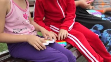 Renkli, yumuşak, silikon köpüklü, duyusal oyuncak, basit gamzeli oyun oynayan sevimli kız çocukları. En üstten orta ekran