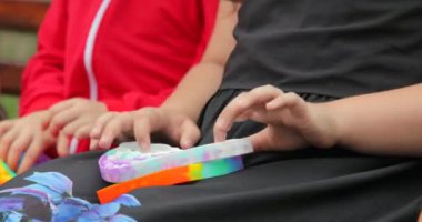 Çocuk kız elleri popüler silikon anti-stres oyuncağıyla oynuyor. Patlat onu ve basit bir gamze. Yakın plan.