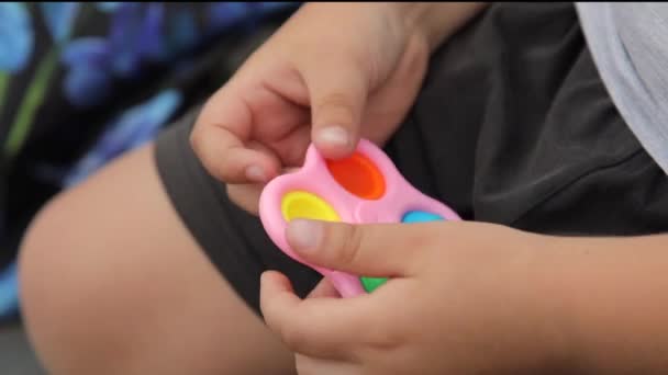 Close-up crianças menino mãos brincando com silicone popular anti-stress brinquedo pop-lo e simples covinha. — Vídeo de Stock