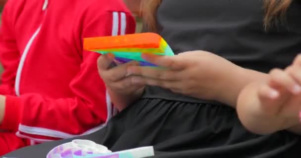 Les mains de fille enfant jouant avec le jouet anti-stress populaire en silicone pop it et fossette simple. Gros plan — Video