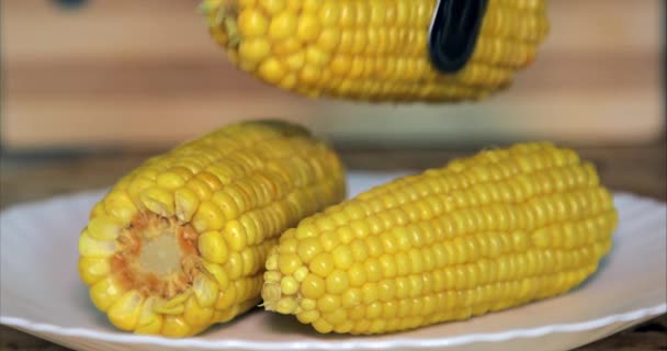 Tatlı sarı sıcak ve taze haşlanmış mısır koçanları mutfakta bir tabakta. Mısırı tabağa koy. — Stok video