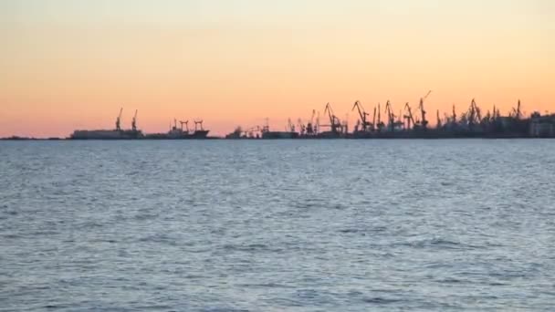 Autumn seaport on the coast of the Ukrainian city of Mariupol with flying birds in front of the camera at sunset. Mariupol before the war with Russia. — стоковое видео