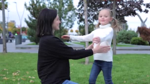 Medium shot of a mother gently hugging her daughter. Cute innocence child girl hugging her mom, smiling and looking at the camera. Mothers Day concept. — Video Stock