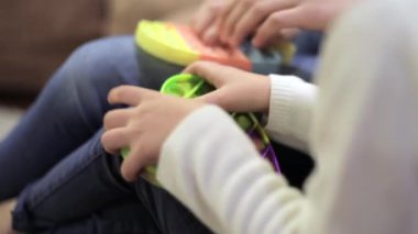 Yoğun bir şekilde popüler silikon anti-stres pop-it oyuncağını oynayan bir kızın ellerine yakın çekim. Anaokulu kızı baloncuklara bastırıyor. Motor becerilerin gelişimi.