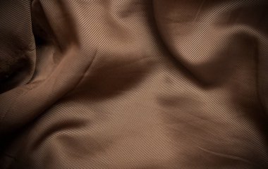 Golden taffeta silk fabric curve making a background.