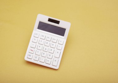 White isolated calculator on yellow banner finance and expenses concept.