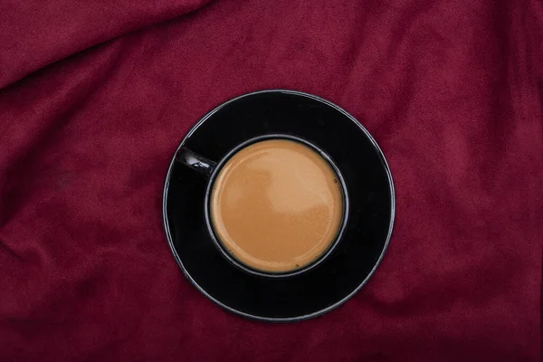 赤いベッドシートに熱い黒茶カップのトップビュー — ストック写真
