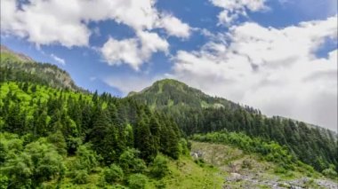 Bereketli yeşil dağların tepesinde hareket eden bulutlar..