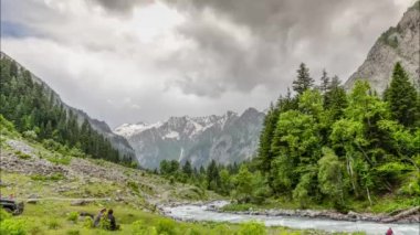 Yeşil vadide kara bulutlar dolaşıyor.