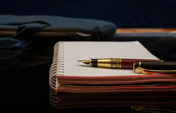 黑色写字台上的日记和钢笔 — 图库照片