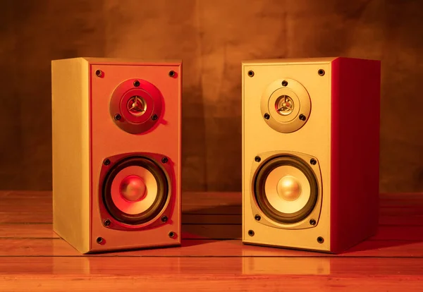 Two audio speakers with yellow and red bar lights closeup view.