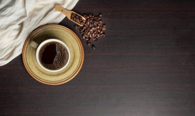 Cup of fresh brewed coffee with beans isolated on dark banner template.