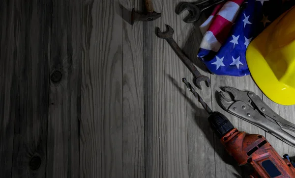 American labor day with hardware tools and American flag on wooden table.