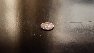 Siyah arkaplanda gümüş bir madeni parayı kapat