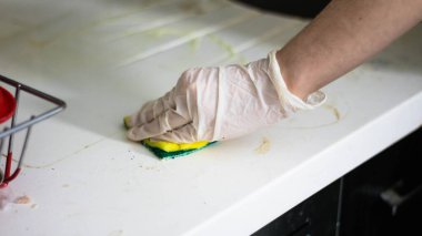 Adam fırçayla mutfağı temizliyor.