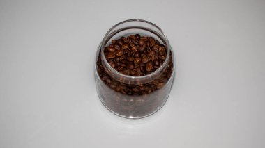 Cam kavanozda kahve çekirdekleri, cam bankada kahve çekirdekleri, beyaz arka planda kahve çekirdekleri. 