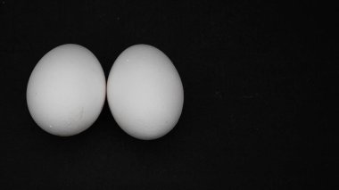 Siyah arka planda beyaz tavuk yumurtası