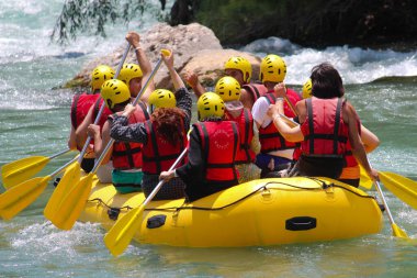 Nehirde kayak yapan bilinmeyen bir grup genç. 