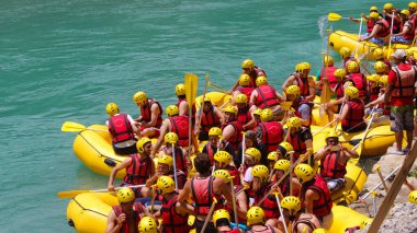 Nehirde kayak yapan bilinmeyen bir grup genç. 