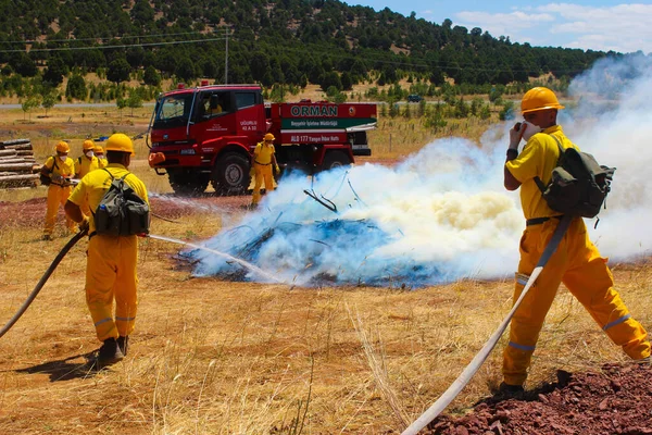 Terk edilmiş bir yangında koruyucu maskeli itfaiyeciler.