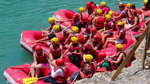 Nehirde kayak yapan bilinmeyen bir grup genç. 