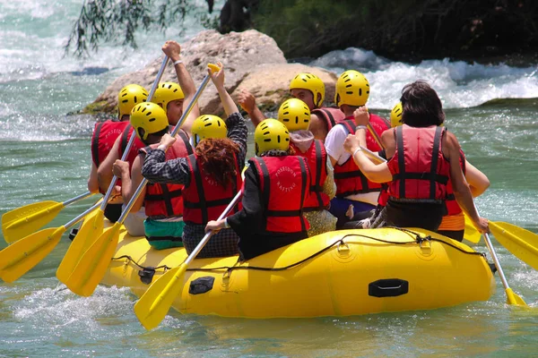 Nehirde kayak yapan bilinmeyen bir grup genç. 