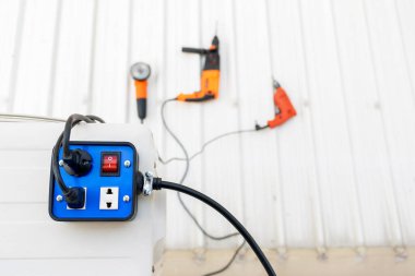 Mavi römork prizine yakın çekim. El aletleri ile kullanmak için açma kapama düğmesi olan 3 priz..