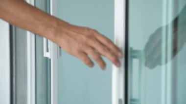 Bir adamın eline yaklaş ve cam kapıyı kapat..