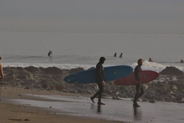 Kaliforniya 'nın Rincon noktasında kış dalgalarında sörf yapmak