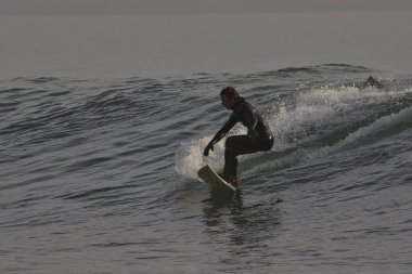Kaliforniya 'nın Rincon noktasında kış dalgalarında sörf yapmak