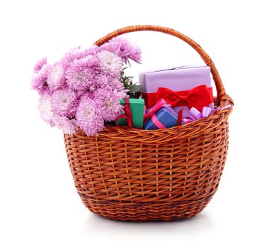 Beyaz arka planda izole edilmiş sepette hediyeler ve kasımpatılar.