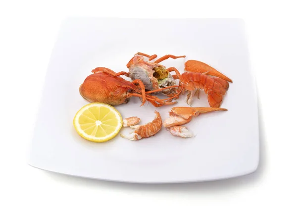 Parts of boiled crayfish with lemon isolated on a white background.