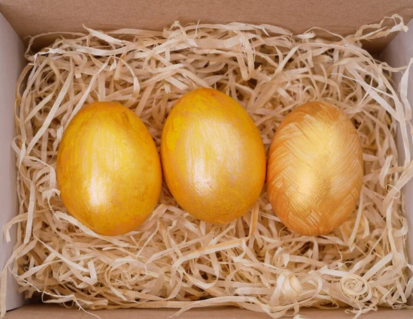 Three Golden Eggs Box Filled Sawdust — Fotografia de Stock