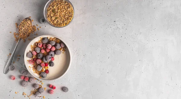 碗的自制酸奶 配上燕麦粉和覆满白霜的冰冻浆果 背景色灰暗 顶部有复制空间 — 图库照片