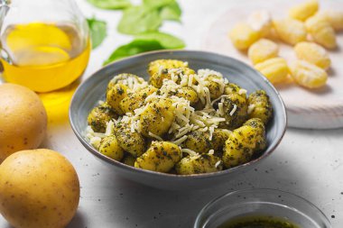 Gri beton arka planda pesto soslu geleneksel gnocchi. Patates ve buğday unuyla hazırlandı. Gnocchi genellikle oval hamur işidir.