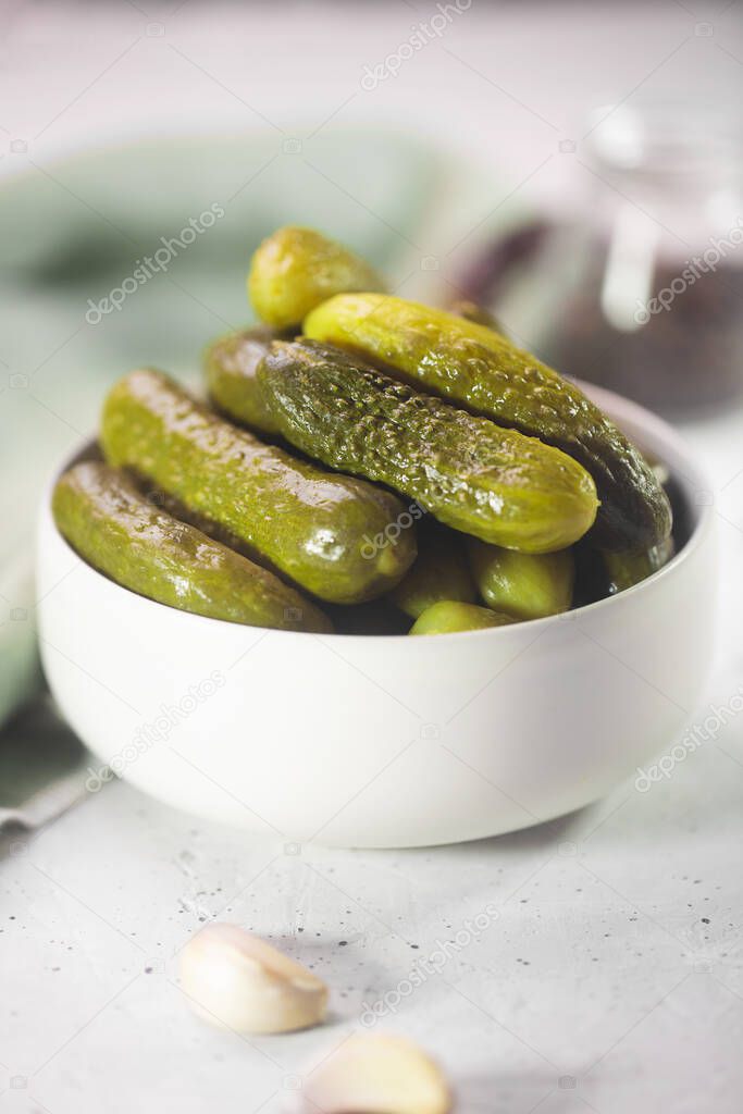 Pickled gherkins. Salted Cucumbers on a white concrete background