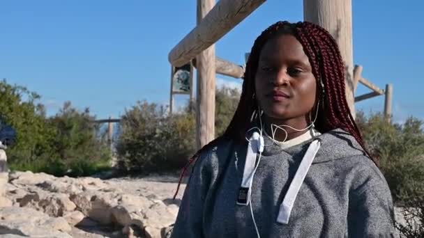 ผู้หญิงแอฟริกันที่มี Dreadlocks กําลังเต้นรํากับภูเขาและท้องฟ้า — วีดีโอสต็อก