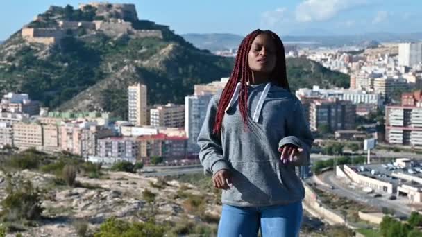 Africká žena s dredy tančí proti hoře — Stock video