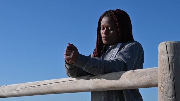 Mujer negra se pone triste contra el cielo — Vídeo de stock