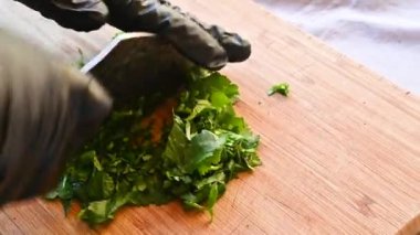 Şef taze maydanozu bıçakla doğruyor.