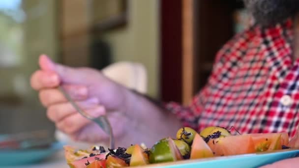Мужчина кладет салат на тарелку дома — стоковое видео
