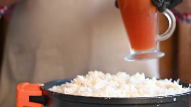 El cocinero prepara el arroz en una sartén y vierte la salsa en la parte superior — Vídeo de stock