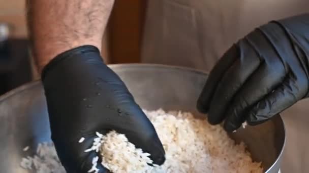 Chef lave le riz cru avec des mains gantées — Video