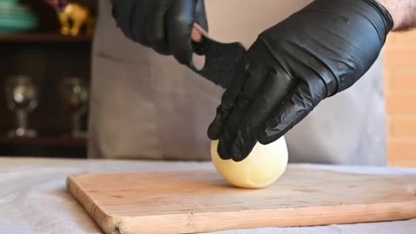 Mężczyzna kucharz w rękawiczki tnie cebula na a cięcia deska — Wideo stockowe