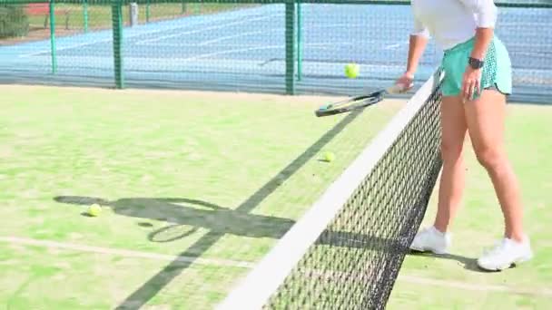 Hermoso jugador de tenis mirando a la cámara y sonriendo — Vídeos de Stock