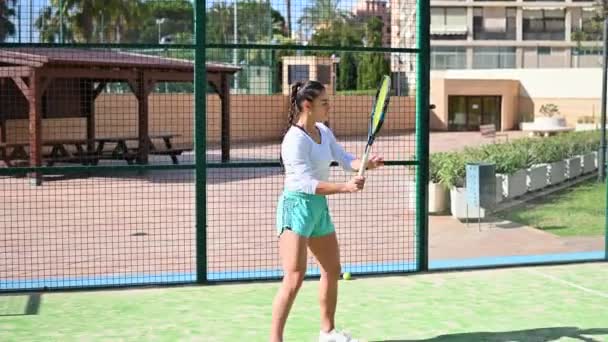 Hermosa mujer juega tenis en el campo — Vídeos de Stock