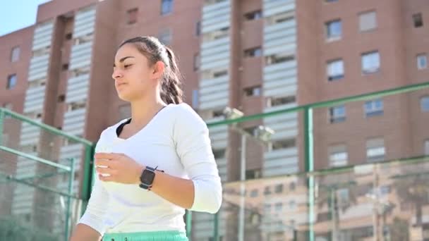 Молодая женщина играет в теннис на строительном фоне — стоковое видео