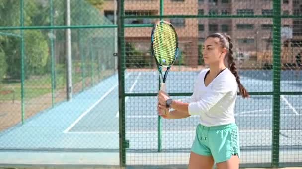 Giovane donna gioca a tennis sul campo — Video Stock