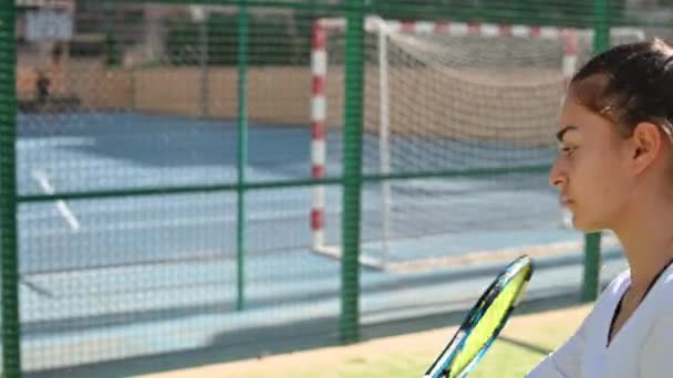 Молодая женщина играет в теннис на поле — стоковое видео
